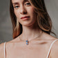 Colgante con forma de gafas de plata sostenible con calcedonia azul, chapadas en oro negro.